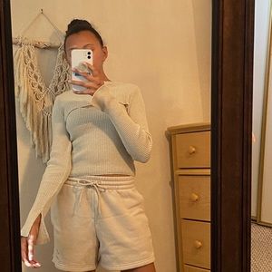 Ribbed tan blouse with connected sleeves.